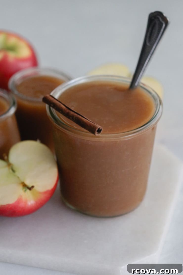 Effortless 4-Ingredient Slow Cooker Apple Butter 5 Jar of homemade paleo apple butter with fresh apples in the background