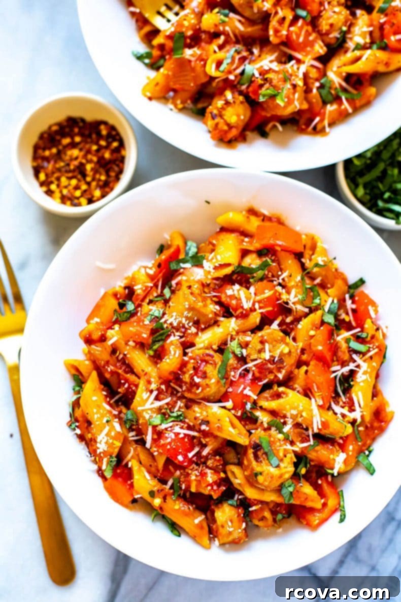 Indulge in this wholesome One-Pot Spicy Penne Arrabiata, a delightful pasta featuring a fiery tomato base, lean turkey sausage, and crisp bell peppers, ready in just 30 minutes for an ideal weeknight dinner solution. A close-up shot of steaming One-Pot Spicy Penne Arrabiata, rich with tomato sauce, turkey sausage, and vibrant red bell peppers, garnished with fresh basil.