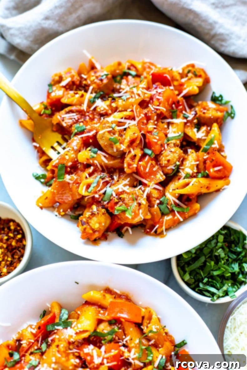 A hearty serving of Spicy Penne Arrabiata dinner, showcasing the vibrant red sauce, tender penne, and flavorful sausage, a fantastic one-pot option for a quick, healthy meal. Two bowls of freshly prepared Spicy Penne Arrabiata with turkey sausage and bell peppers, topped with grated Parmesan and fresh basil, ready to serve.