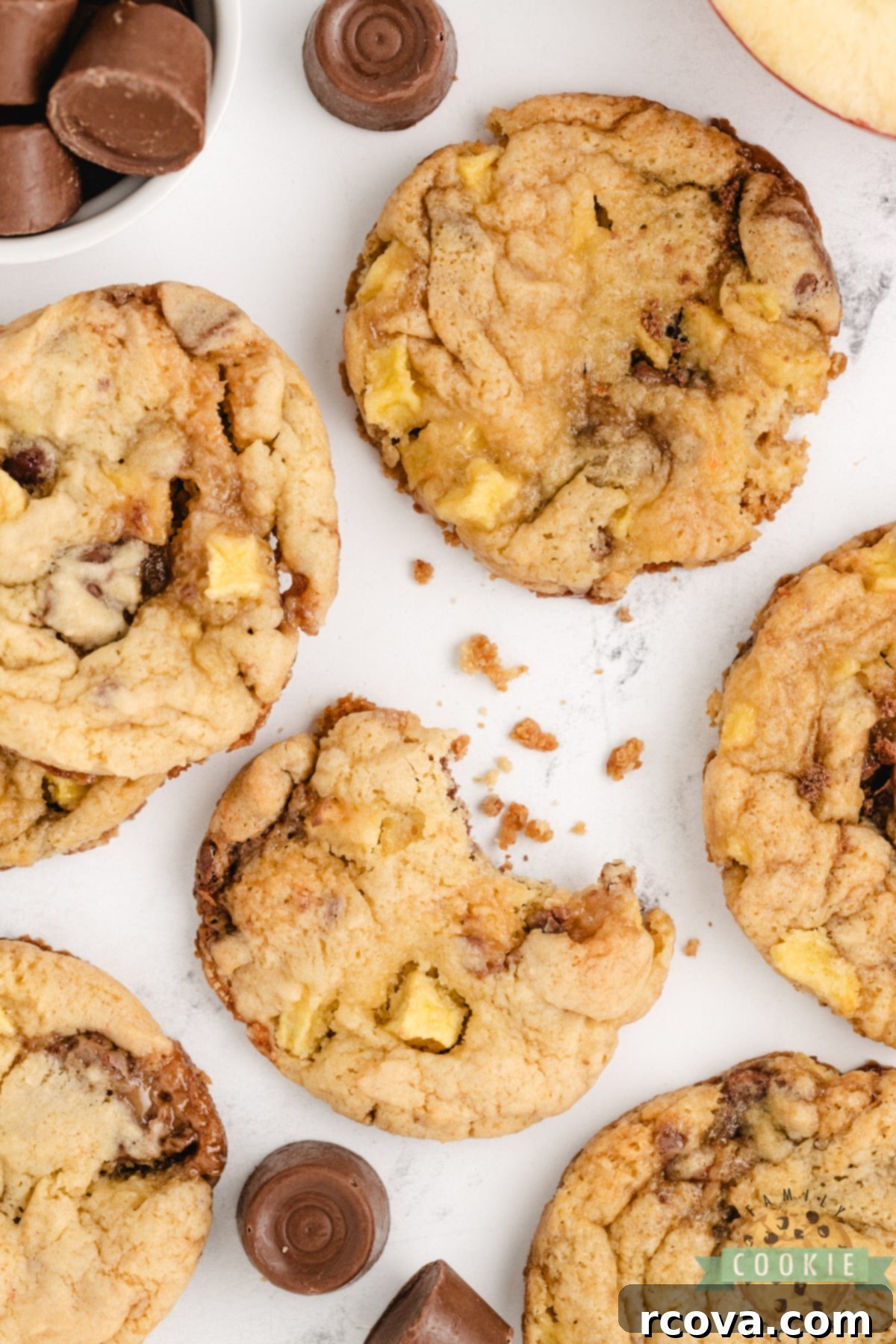 Irresistible Caramel Apple Cake Mix Cookies 5 Close-up photo of several unbaked cookie dough balls on a baking sheet, featuring visible chunks of apple and Rolo candy.