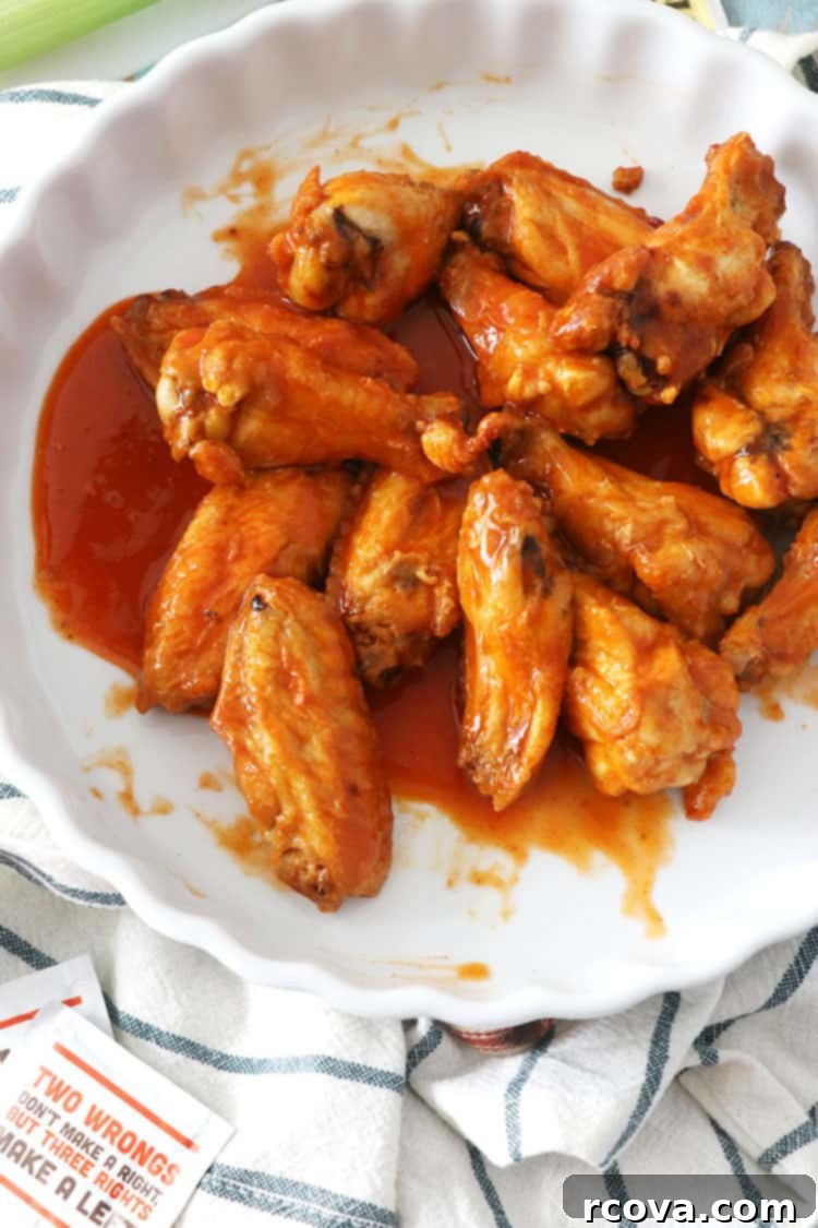 Guilt-Free Crispy Buffalo Wings 9 A close-up of several air fryer buffalo wings piled high, with a sauce drizzle.