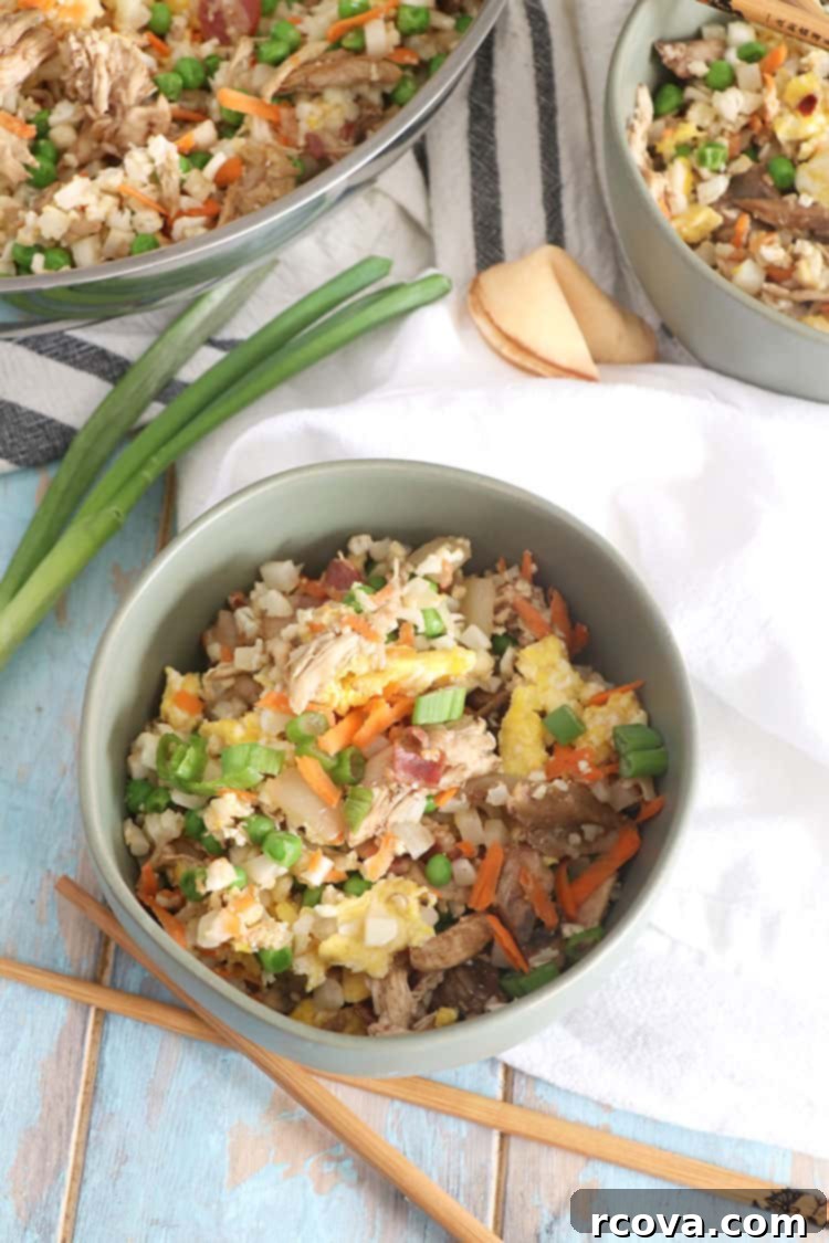 Cauliflower Chicken Fried Rice Whole30 Keto Paleo Approved 3 Close-up of the Cauliflower Chicken Fried Rice in a skillet, mid-cooking, showing the ingredients mixing.