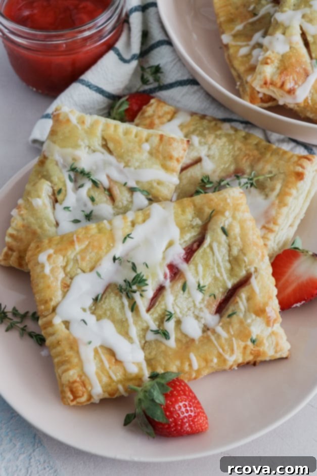 Strawberry Thyme Chevre Pockets 6 A single strawberry, thyme, and goat cheese hand pie on a plate, garnished with fresh thyme.