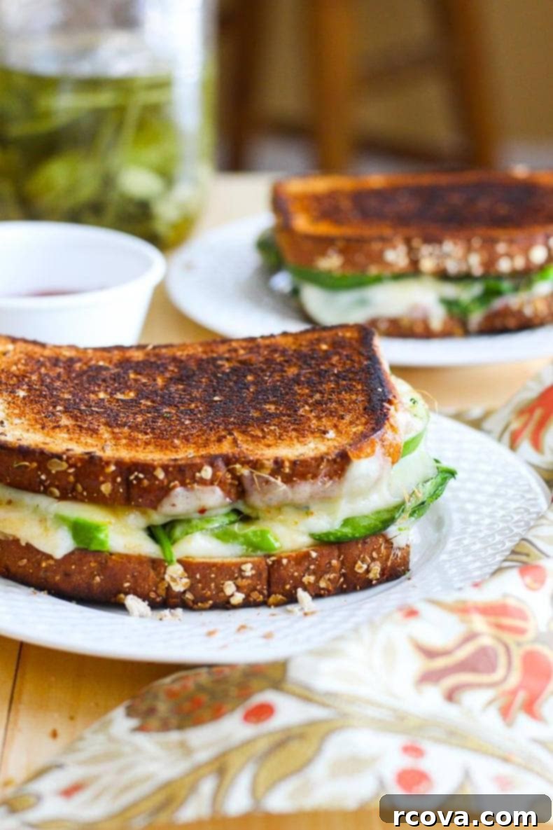 Green Goddess Melt 7 Green Goddess Grilled Cheese Sandwich cut in half on a wooden board