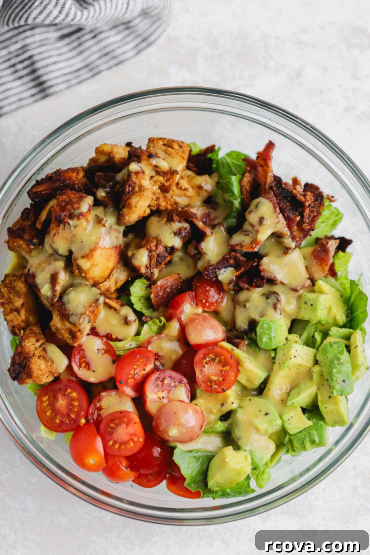 Dijon-Kissed Grilled Chicken & Bacon Salad 3 Fresh salad ingredients including lettuce, tomatoes, and avocado in a large bowl, ready for assembly.