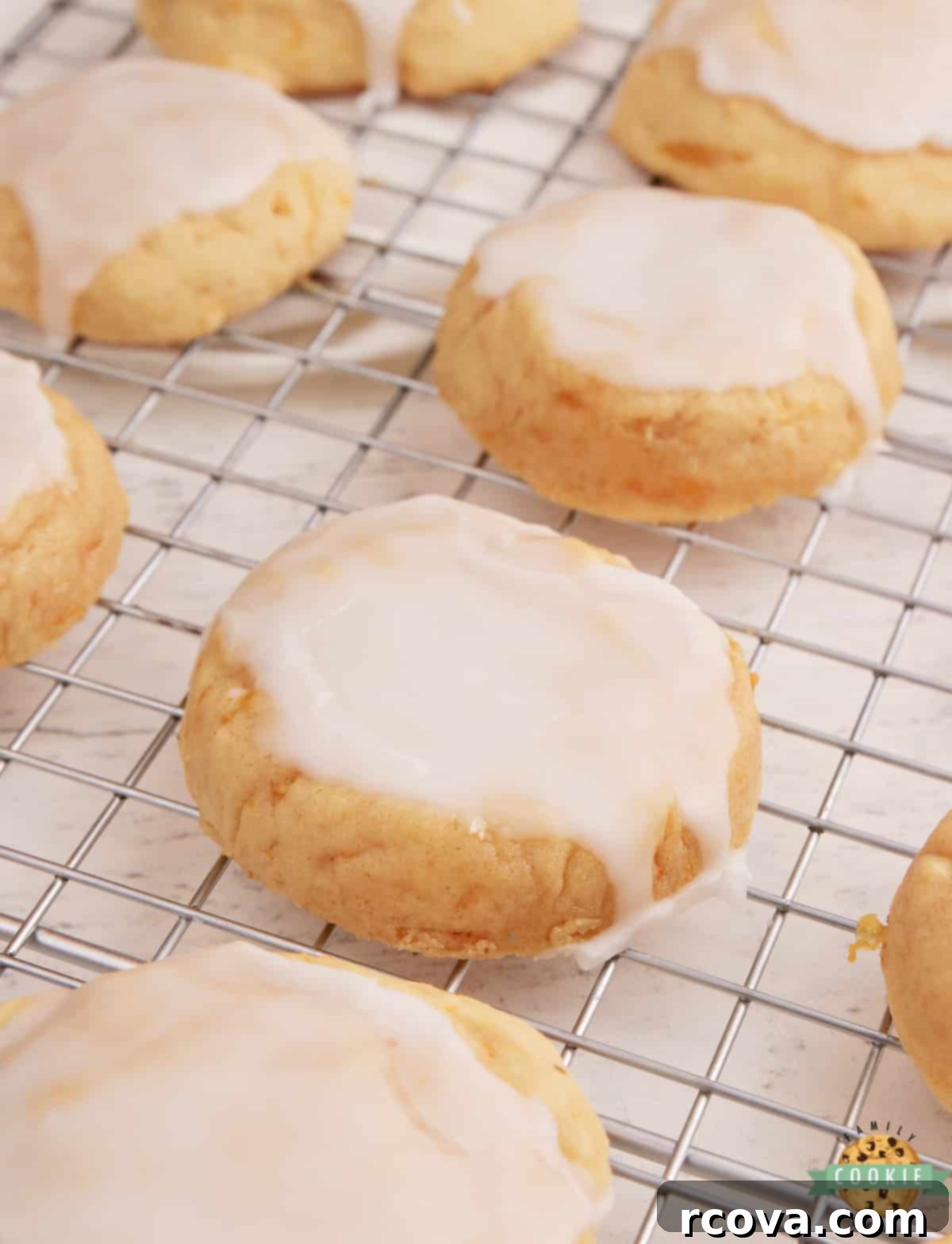 Zesty Mandarin Glazed Cookies 7 Glazed Mandarin Orange Cookies spread out on a white surface, showing off their delicate glaze.