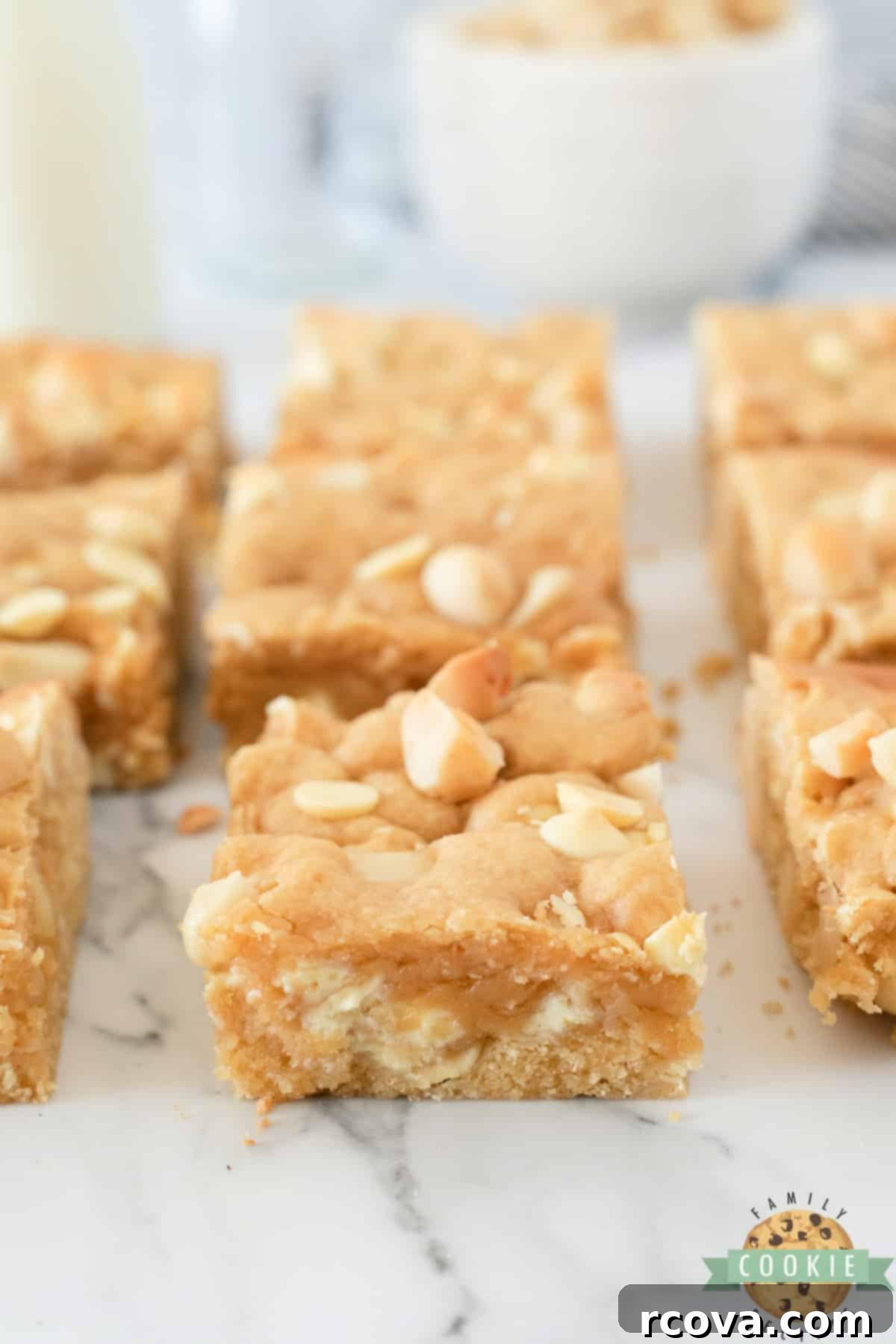 Irresistible White Chocolate Macadamia Blondies 9 A stack of soft and thick White Chocolate Macadamia Cookie Bars, highlighting their irresistible chewiness.