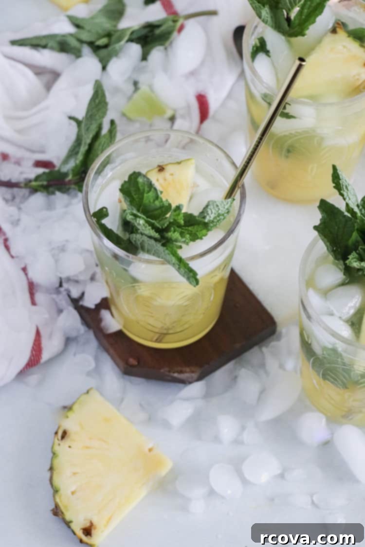 Pineapple Paradise Mojito 4 Sparkling Pineapple Mojito in a tall glass with pineapple slice
