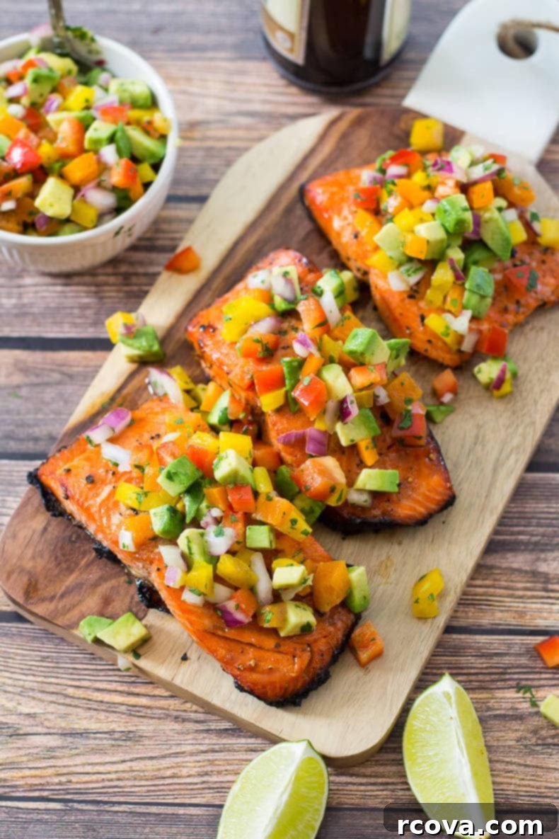 Effortless Grilled Salmon with Zesty Avocado Salsa 5 Grilled salmon fillets topped with fresh avocado salsa on a serving board