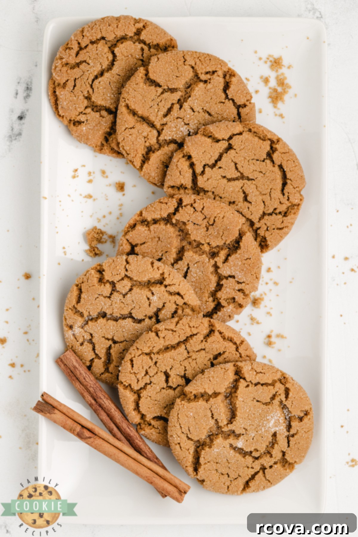 Cozy Ginger-Spiced Cookies 5 A stack of soft gingerbread cookies cooling on a wire rack, adorned with festive ribbons and cinnamon sticks nearby, ready for serving or gifting.