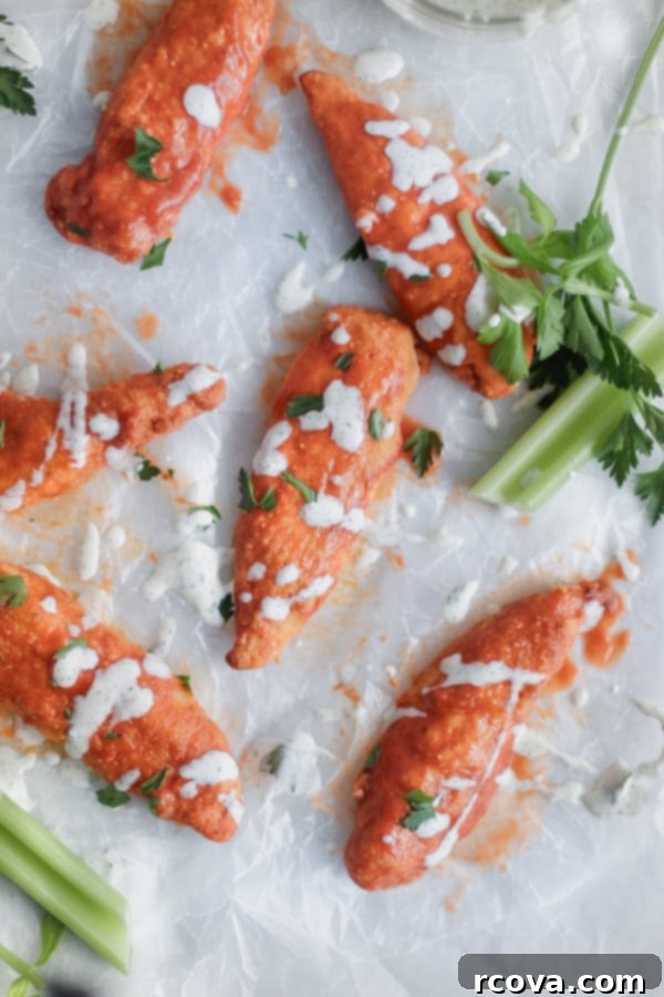 Crispy Air-Fried Gluten-Free Buffalo Tenders 2 Crispy gluten-free buffalo chicken tenders fresh out of the air fryer, coated in vibrant red buffalo sauce.