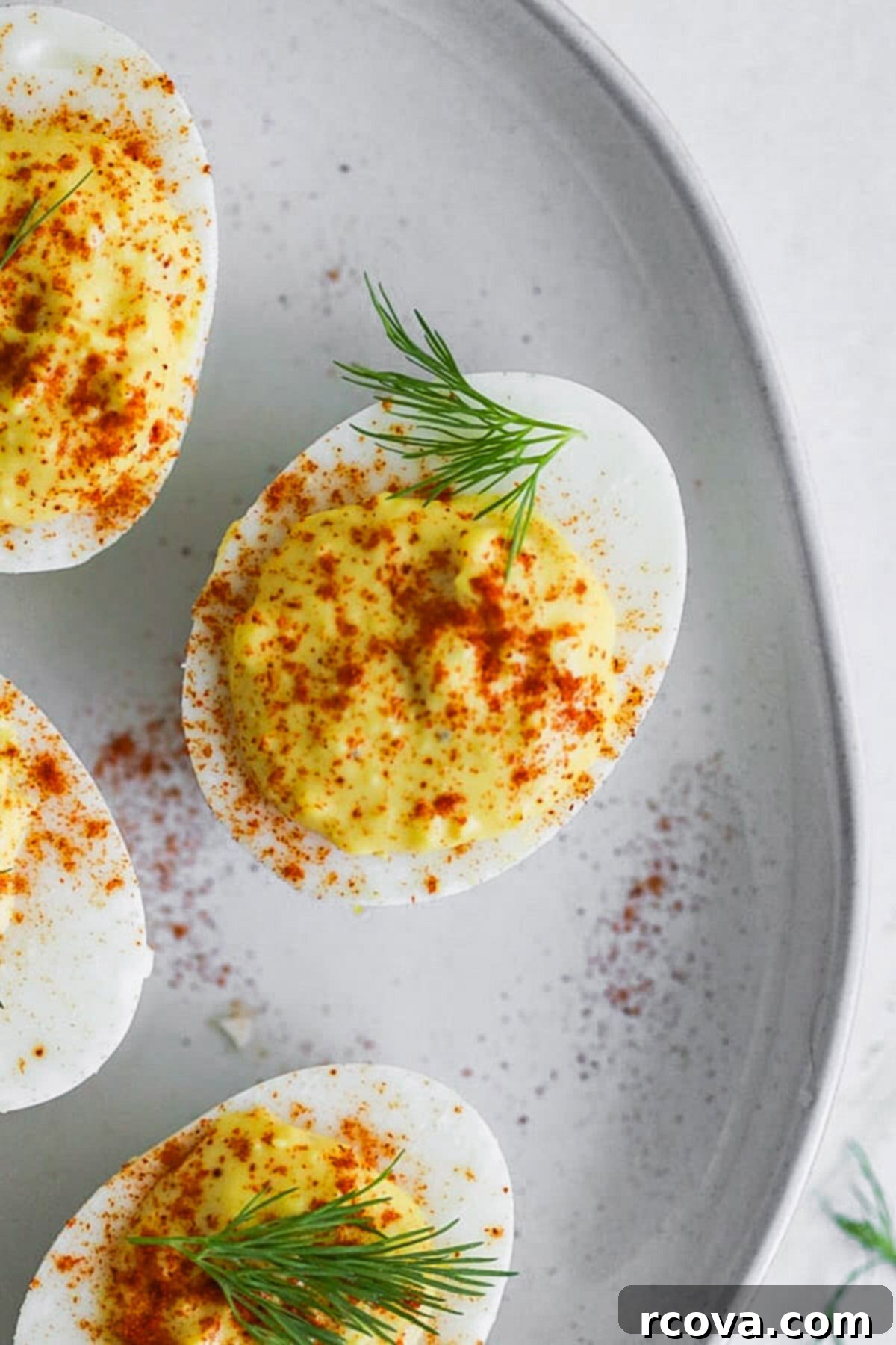 Instant Pot Deviled Eggs Fast & Fabulous 2 A beautifully arranged platter of classic deviled eggs, garnished with paprika and fresh dill, showcasing their creamy texture and appealing presentation.