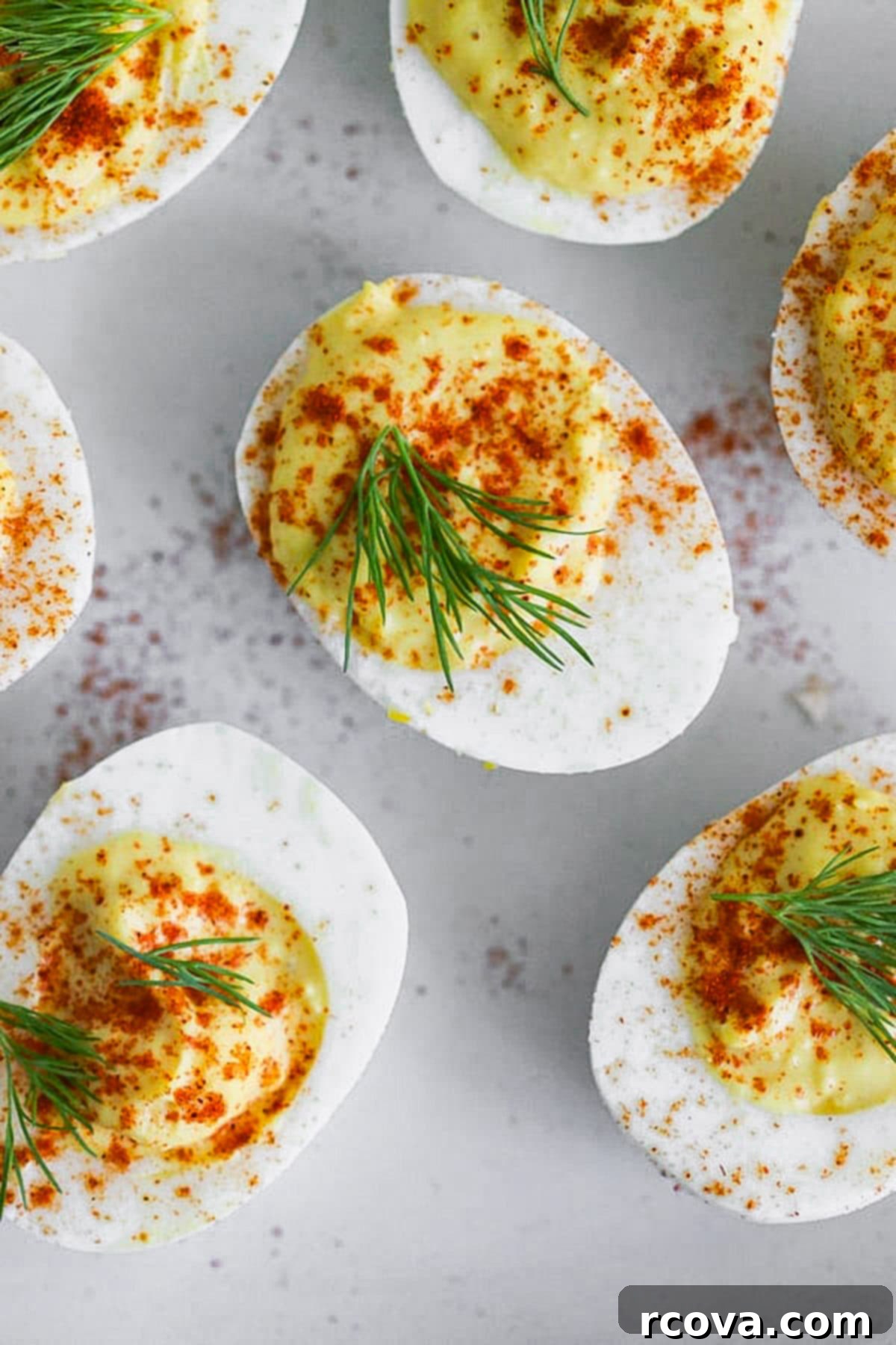 Instant Pot Deviled Eggs Fast & Fabulous 8 A close-up shot of a finished deviled egg, piped with creamy filling and garnished with paprika, showcasing its perfect texture and appetizing appearance.