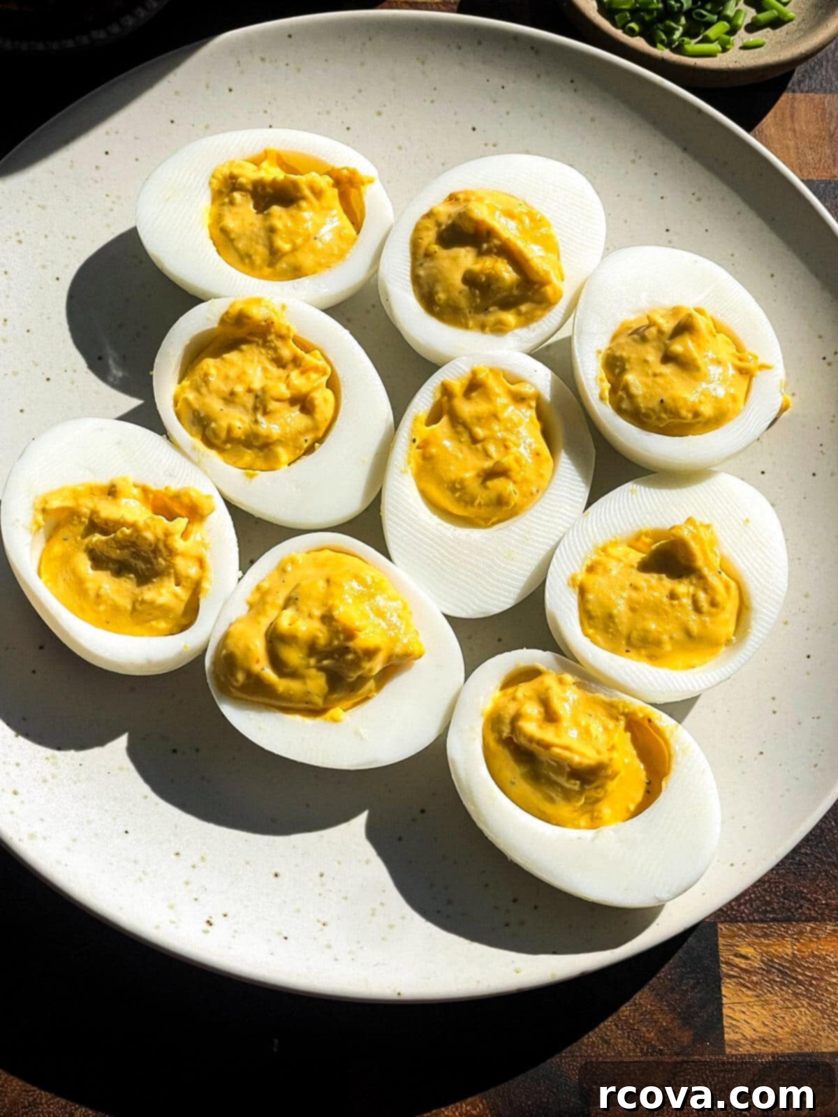 Zingy Pickle Deviled Eggs 6 Another perspective of Southern deviled eggs on a serving platter, showcasing their creamy filling and vibrant garnishes.