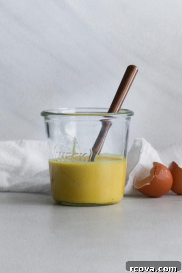 Easy Whole30 Blender Hollandaise 7 Delicious Whole30 Hollandaise Sauce in a rustic white serving bowl, emphasizing its homemade appeal.