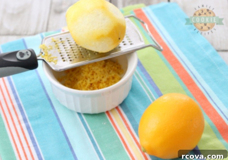 Sunshine Lemon Bars 3 Close-up of hands zesting a fresh lemon to show the process.