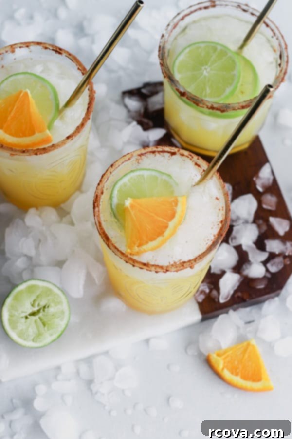 Sparkling Mimosa Margaritas 2 Bright Mimosa Margaritas garnished with orange and lime slices, ready for a celebration