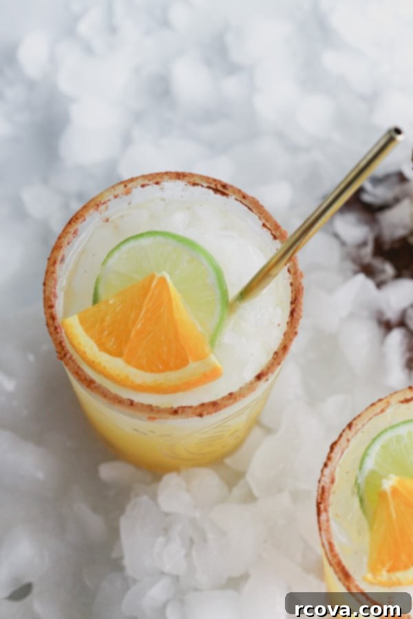 Sparkling Mimosa Margaritas 5 A hand pouring sparkling wine into a glass of Mimosa Margarita mix