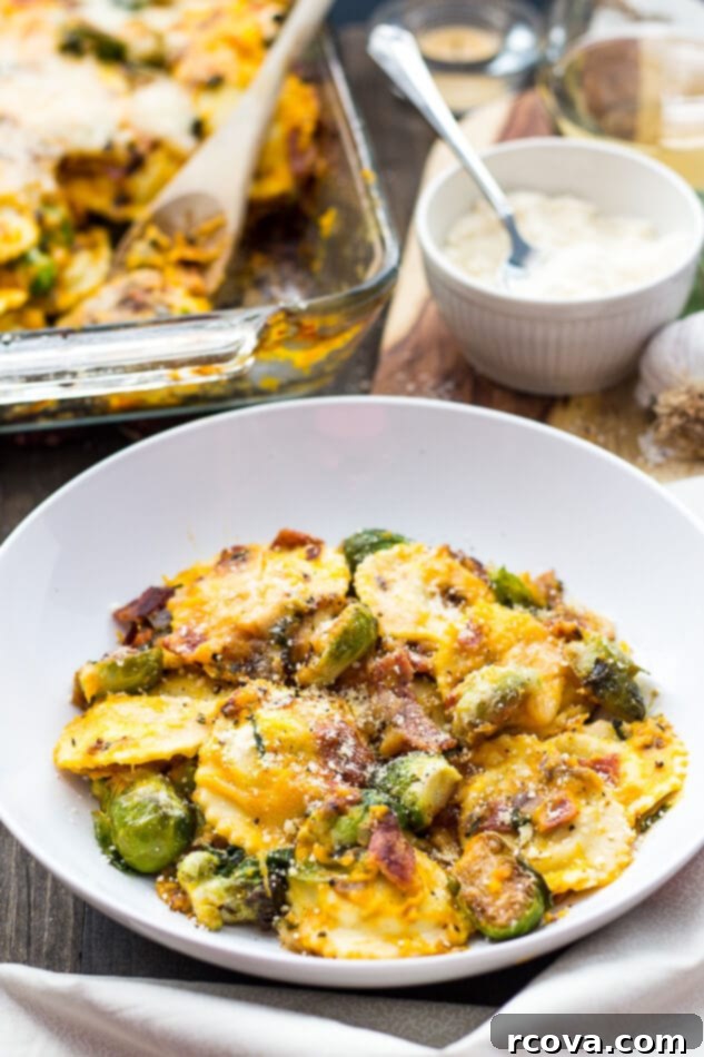 Butternut Squash Ravioli Casserole 2 Butternut Squash Ravioli Bake, golden brown and bubbly from the oven, served in a white baking dish.