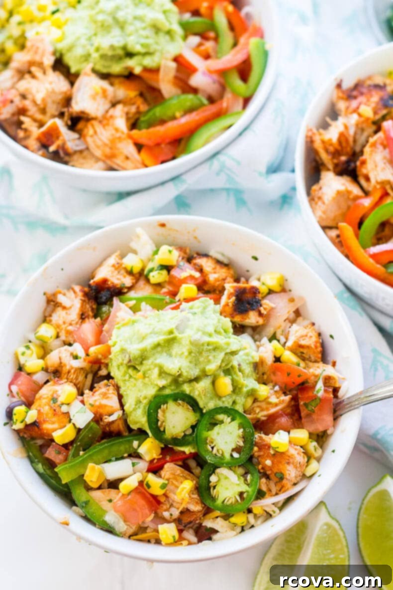 Chipotle Chicken Bowl Extravaganza 2 A vibrant Chipotle Chicken Burrito Bowl featuring grilled chipotle chicken, colorful bell peppers, red onion, corn salsa, pico de gallo, and a scoop of fresh guacamole, served over rice.