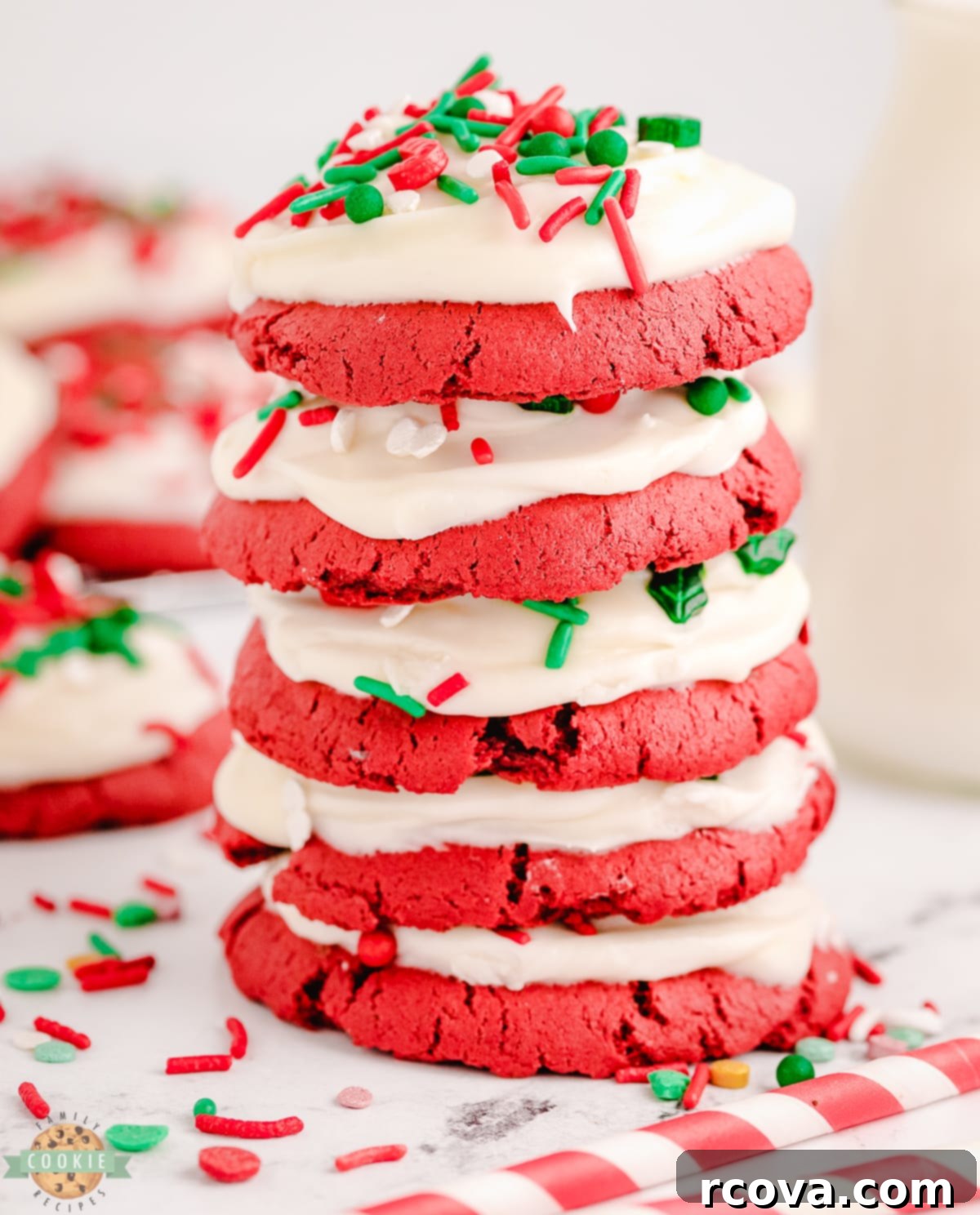 Crimson Velvet Holiday Treats 11 Stack of four red velvet cookies topped with white cream cheese frosting and colorful Christmas sprinkles, ready for a holiday treat