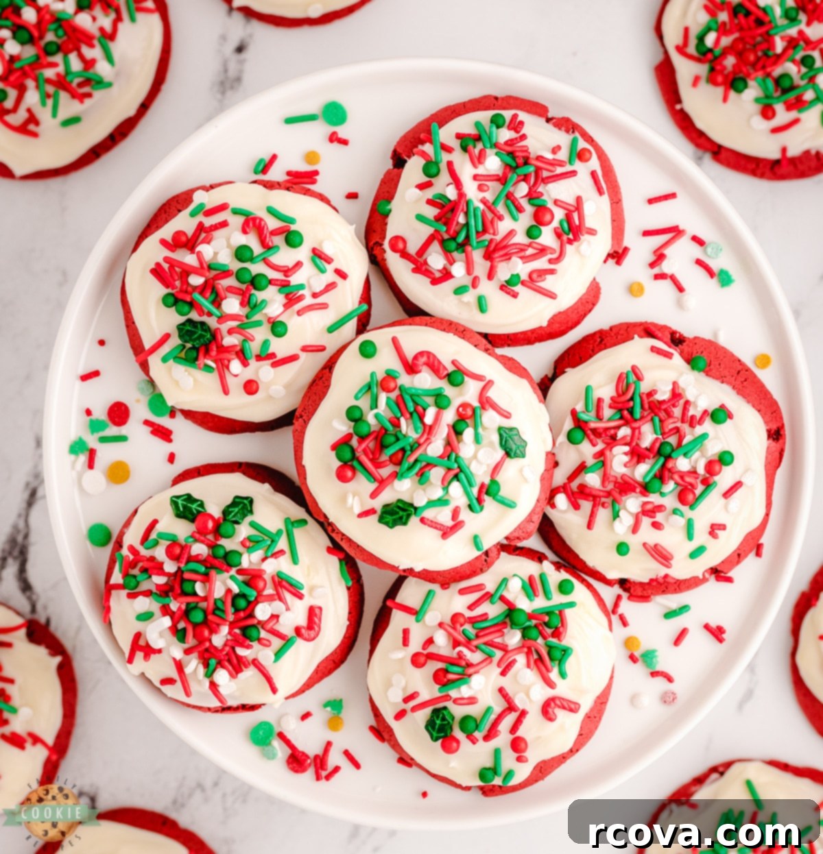 Crimson Velvet Holiday Treats 4 A charming plate filled with perfectly round red velvet cookies, some frosted with white cream cheese icing and festive sprinkles