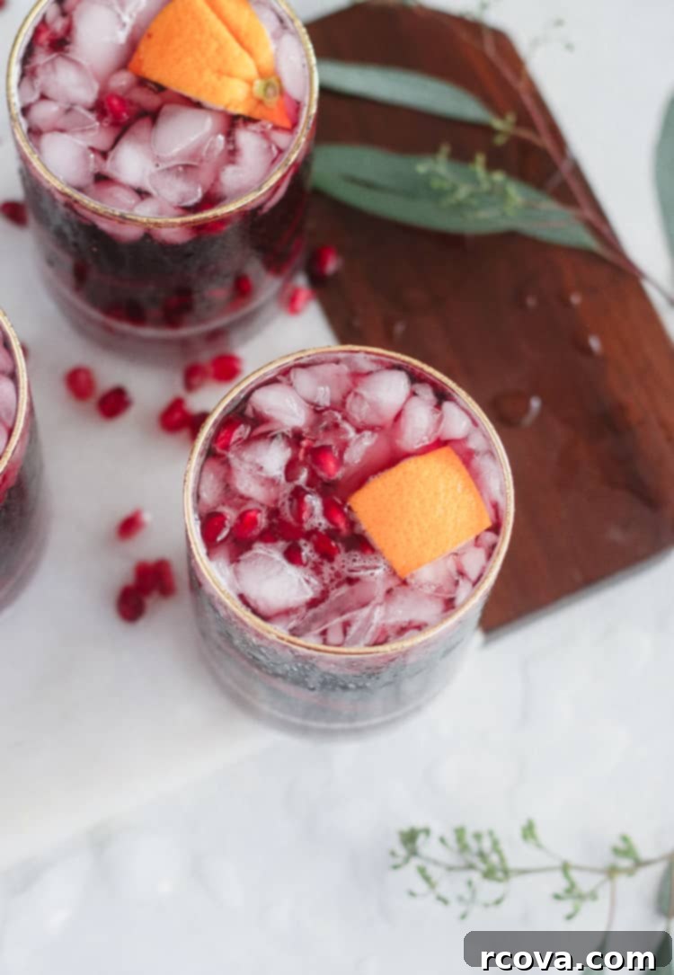 Garnet Pinot Punch 5 Pomegranate Pinot Punch in a large glass pitcher with orange slices and pomegranate seeds.