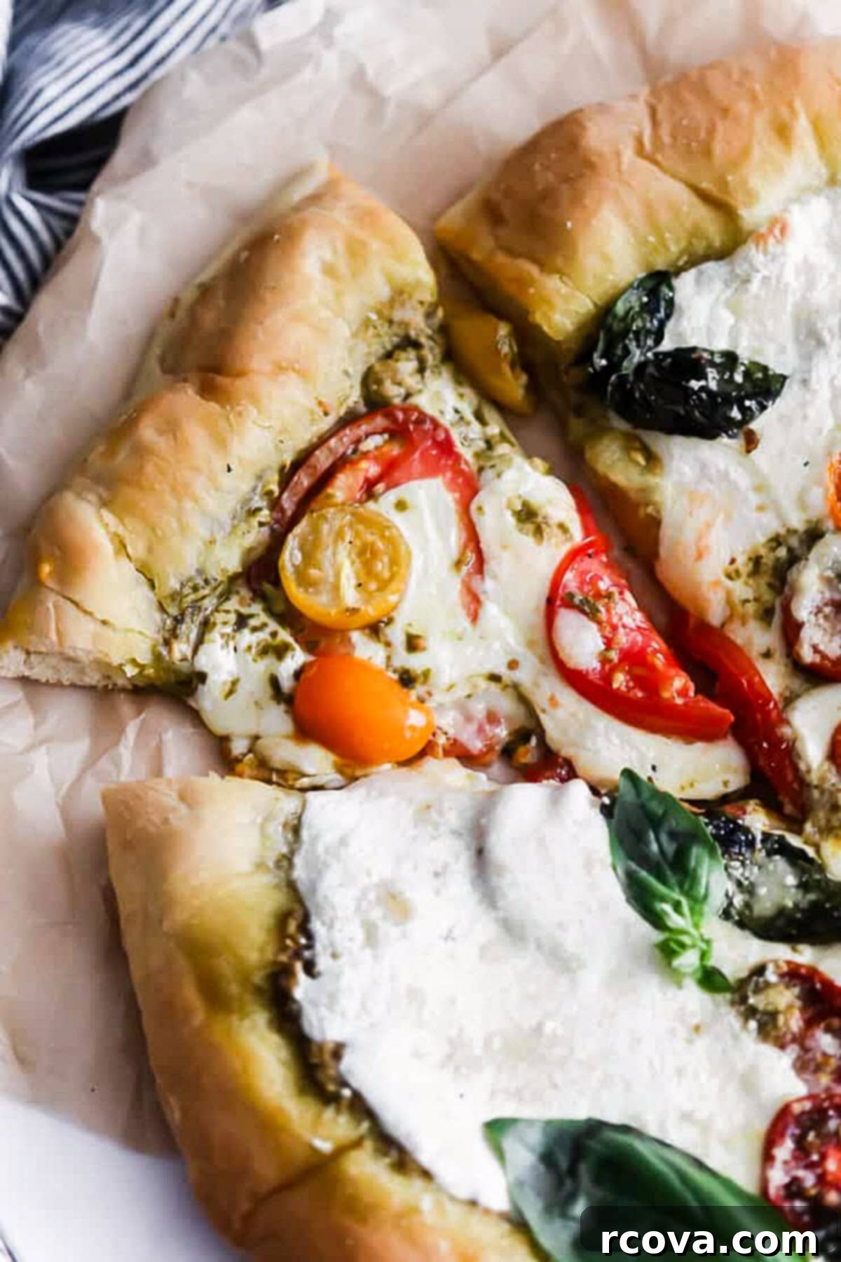 10-Minute Dough Pesto Caprese Pizza 3 Close-up of fresh basil leaves and torn mozzarella on Caprese pizza before baking.