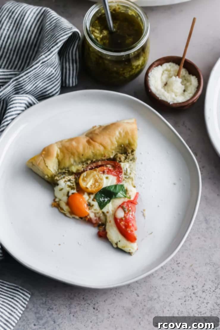 10-Minute Dough Pesto Caprese Pizza 9 Two slices of pesto caprese pizza on a wooden board.