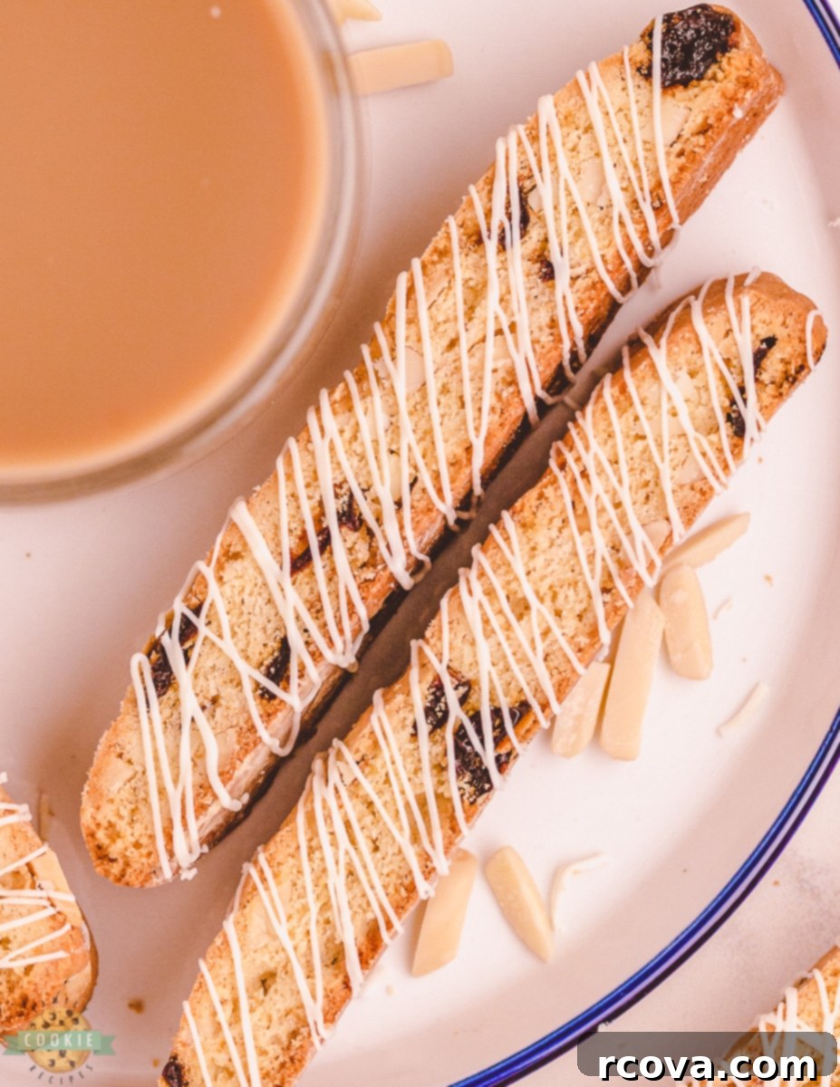 Double-Baked Cherry Delights 7 Two white chocolate cherry almond biscotti on a plate with coffee in the background