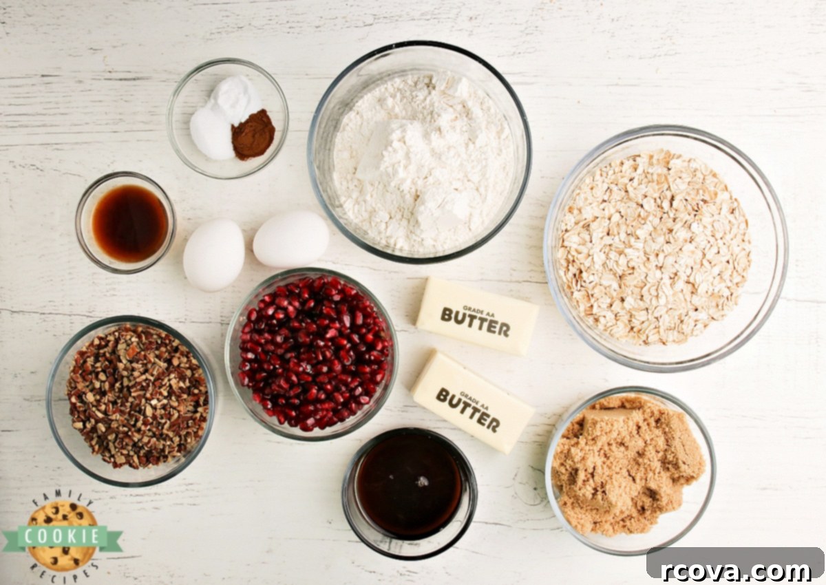 Ruby Glazed Pomegranate Oat Treats 5 A collection of fresh ingredients laid out, including oats, flour, sugar, eggs, butter, cinnamon, pecans, and pomegranate seeds.