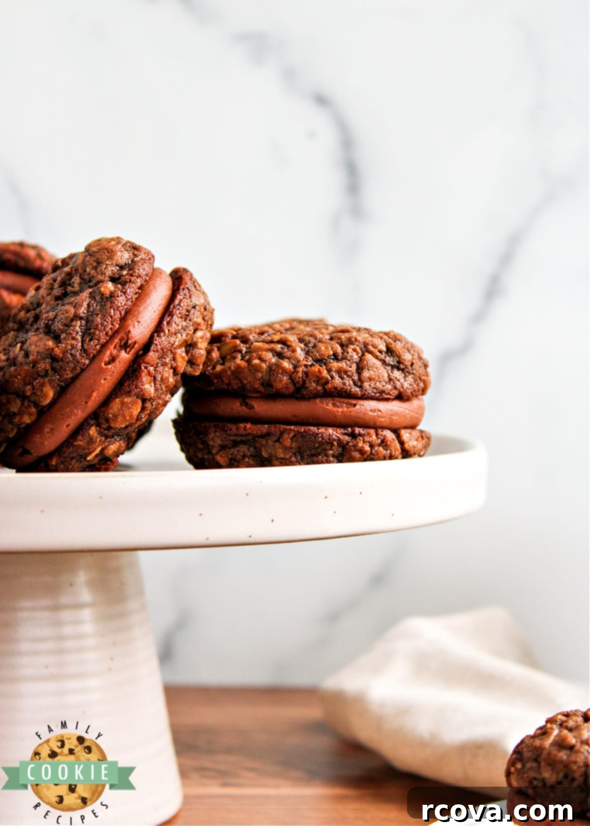 Velvet Chocolate Oatmeal Cream Pies 13 A single Chocolate Oatmeal Cream Pie on a white plate with a fork, ready to be eaten