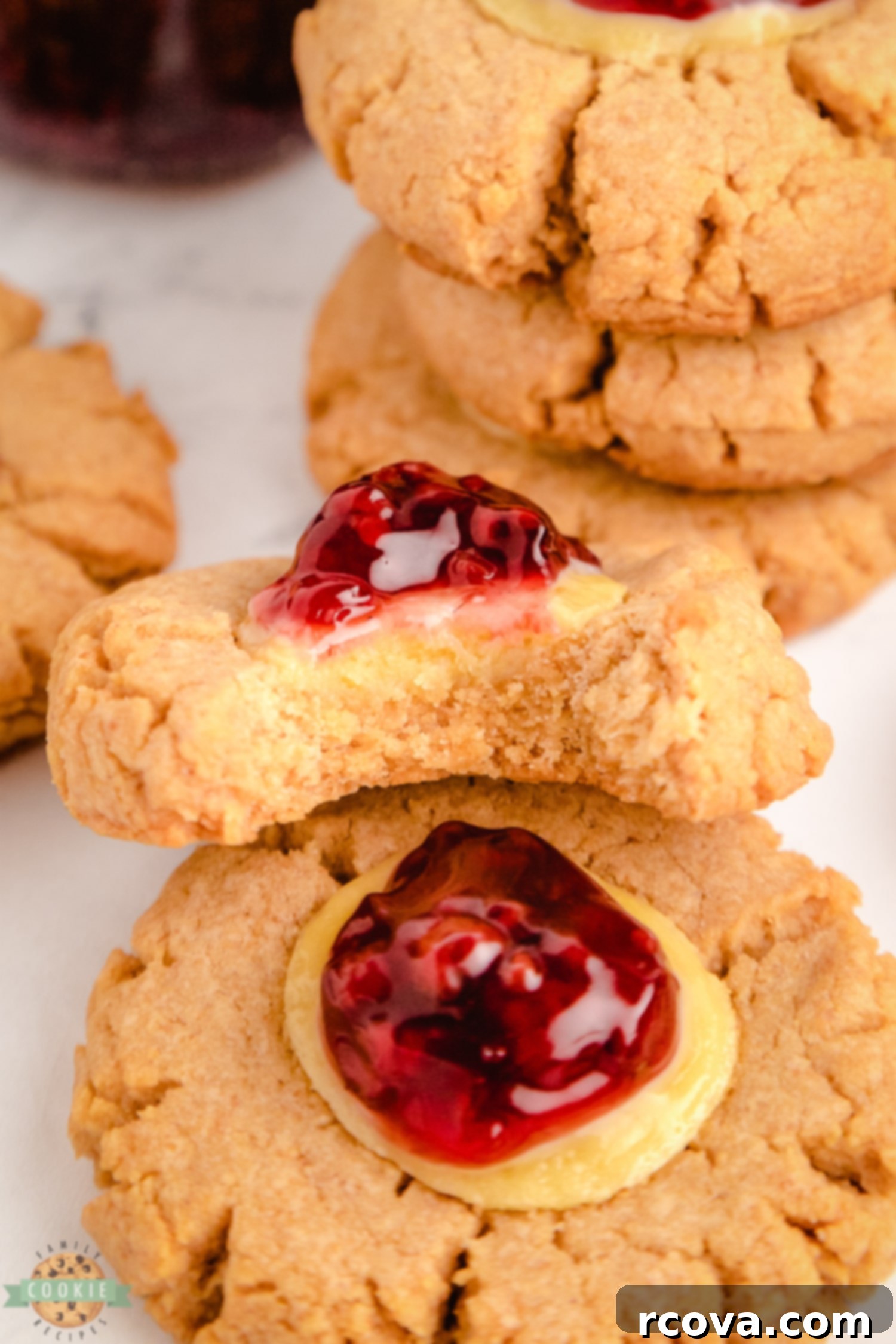 Dreamy Raspberry Cheesecake Cookies 2 A perfectly baked raspberry cheesecake cookie with a bite taken out, revealing its creamy center and graham cracker base.