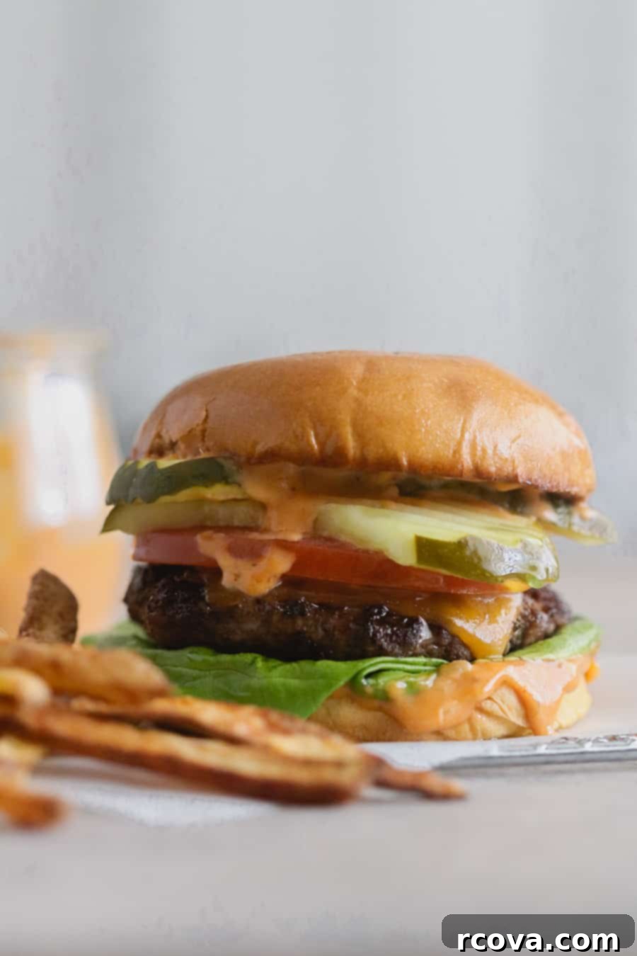 Flawless Grilled Beef Burgers 5 Plated grilled beef burger with melted cheese and fresh vegetables