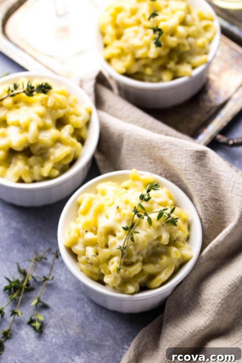 Decadent White Truffle Cheddar Mac 9 A large serving of White Cheddar Truffle Mac and Cheese, with a spoon ready to scoop, illustrating its appealing texture and generous portion.