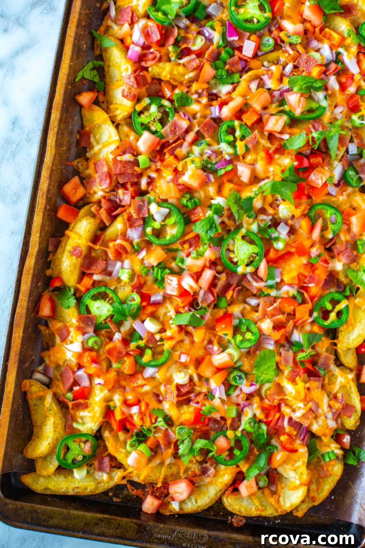Hearty Irish Pub Nachos 10 Another close-up of a perfectly prepared batch of Irish nachos, generously adorned with toppings and melted cheese, presented on a baking sheet.