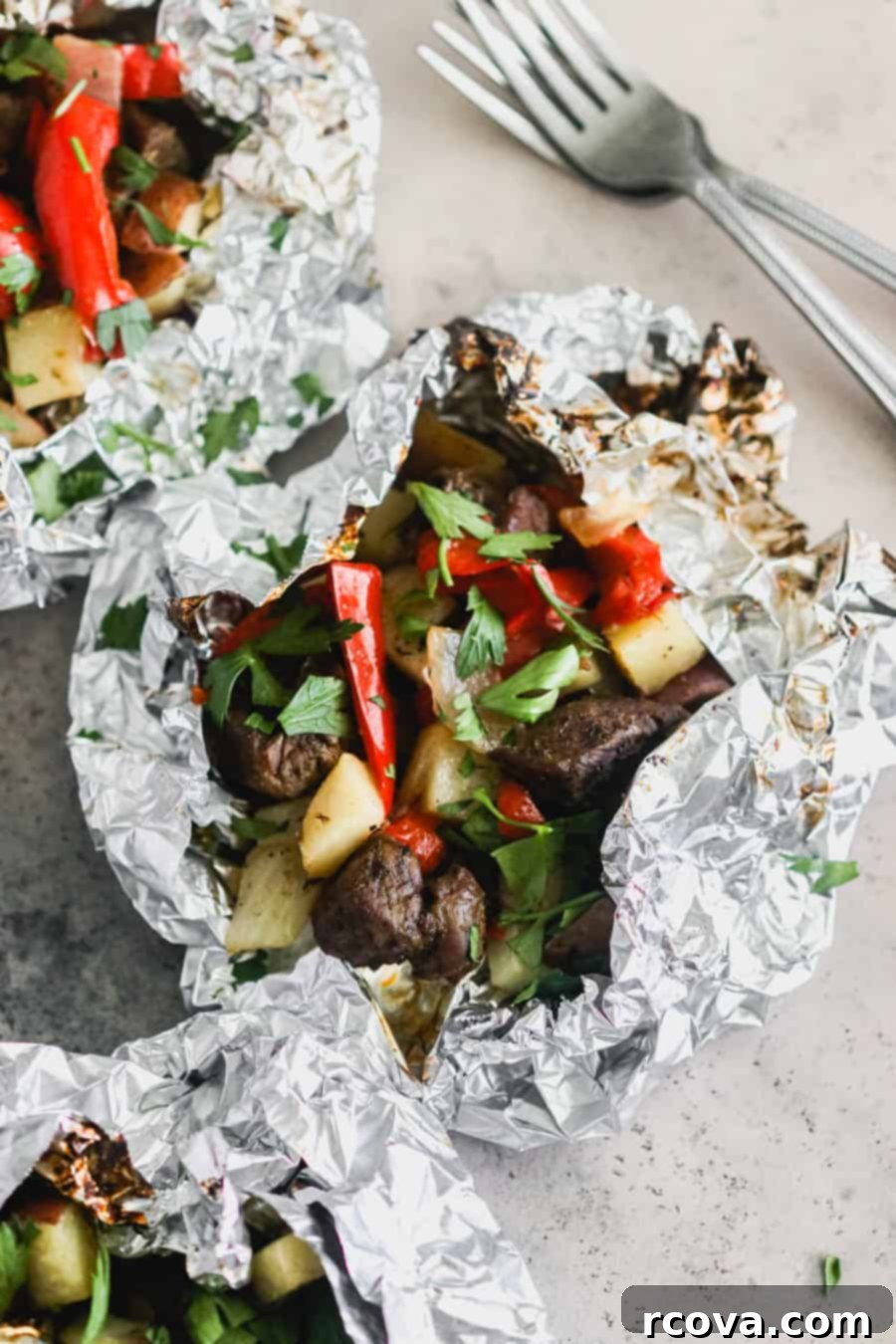 Fire Up Steak and Pepper Foil Dinners 2 Steak and Pepper Foil packets on the grill, showcasing a delicious grilled dinner