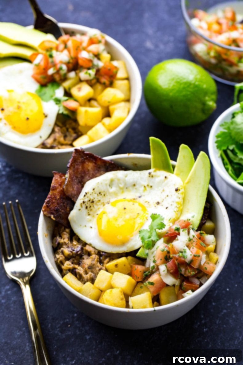 Ranchero Yumurta Kaseleri 2 A vibrant Huevos Rancheros Breakfast Bowl featuring a fried egg, crispy hash browns, turkey bacon, creamy avocado, homemade refried beans, and fresh pico de gallo, ready for a healthy meal.