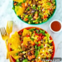 Crispy Dorito Taco Salad 10 Two vibrant bowls of Dorito Taco Salad, generously topped with extra taco sauce, showcasing a medley of colorful ingredients.