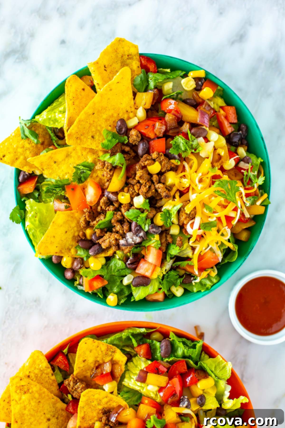 Crispy Dorito Taco Salad 7 A close-up shot of a single bowl of vibrant Dorito Taco Salad, highlighting the layers of ground beef, fresh vegetables, cheese, and crunchy Doritos.