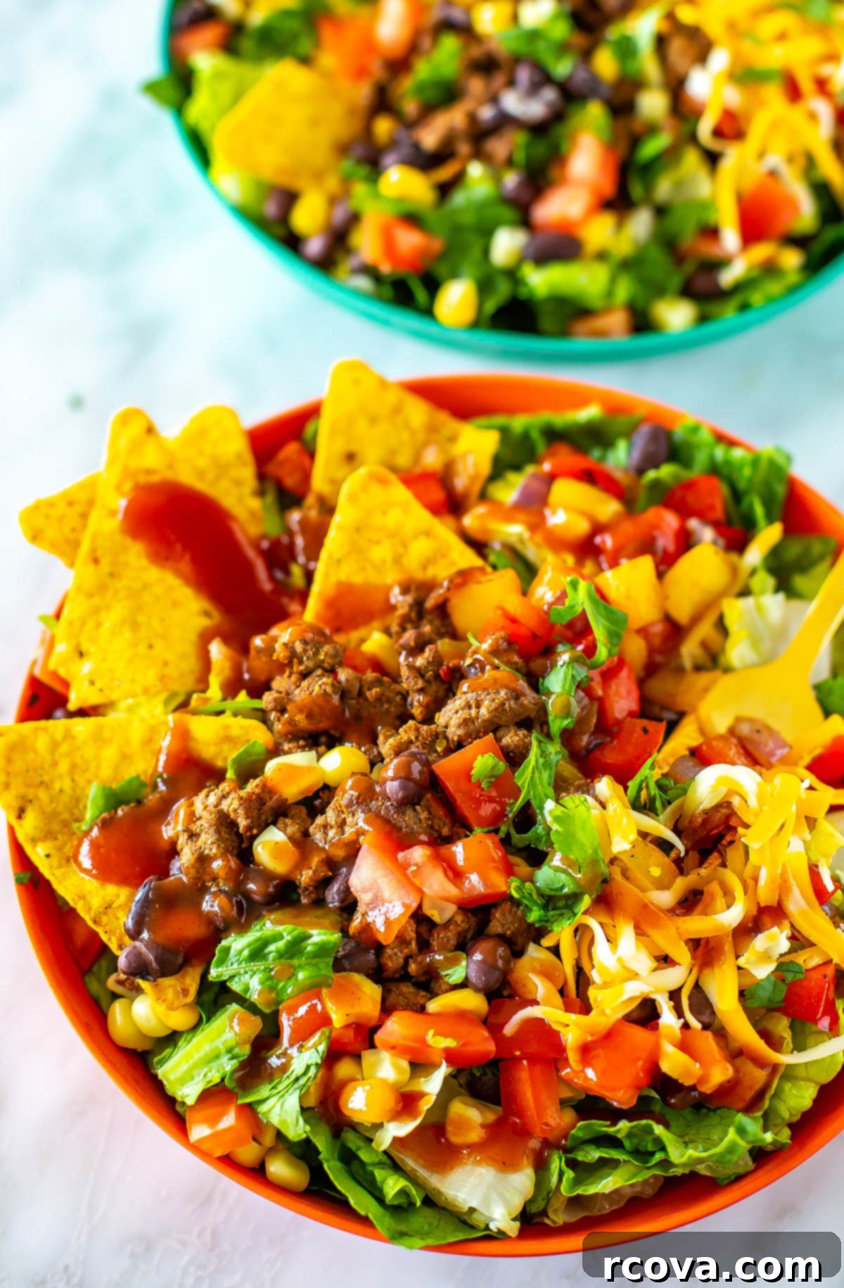 Crispy Dorito Taco Salad 8 A vibrant close-up of a bowl of Dorito Taco Salad, generously dressed with extra taco sauce and a sprinkle of fresh cilantro, ready to be enjoyed.
