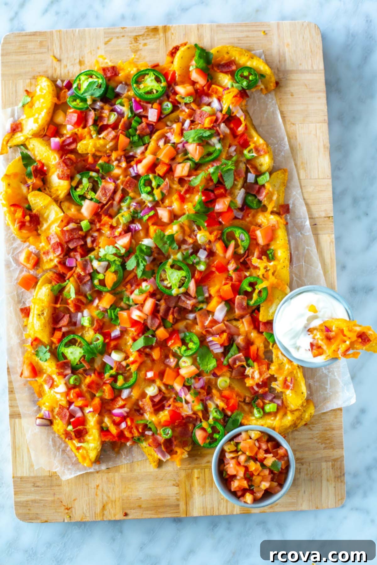 30 Festive Green Recipes for St Patricks Day 10 A butcher block with a serving of Irish nachos alongside two dipping sauces.