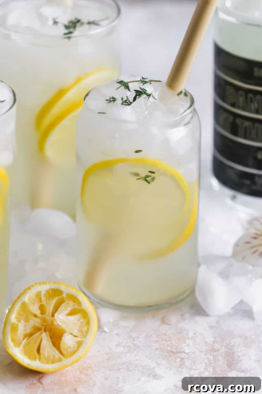 Spiked Patio Lemonade 2 Refreshing Boozy Backyard Lemonade served in glasses with lemon and herb garnish