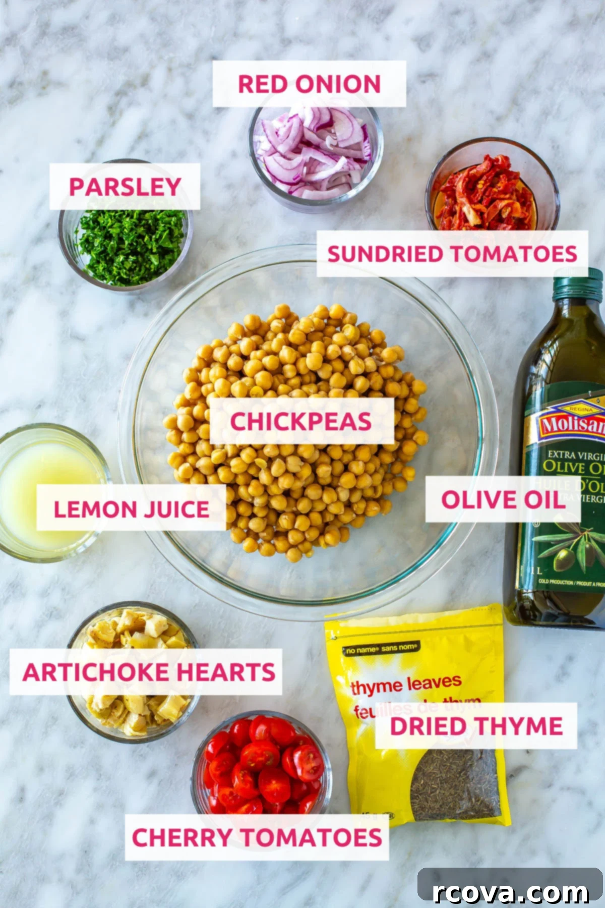 Effortless Mediterranean Chickpea Salad 4 A vibrant flat lay of ingredients for Mediterranean chickpea salad jars: chickpeas, olive oil, red onion, fresh parsley, sun-dried tomatoes, lemon juice, artichoke hearts, cherry tomatoes, and dried thyme, arranged on a white surface.