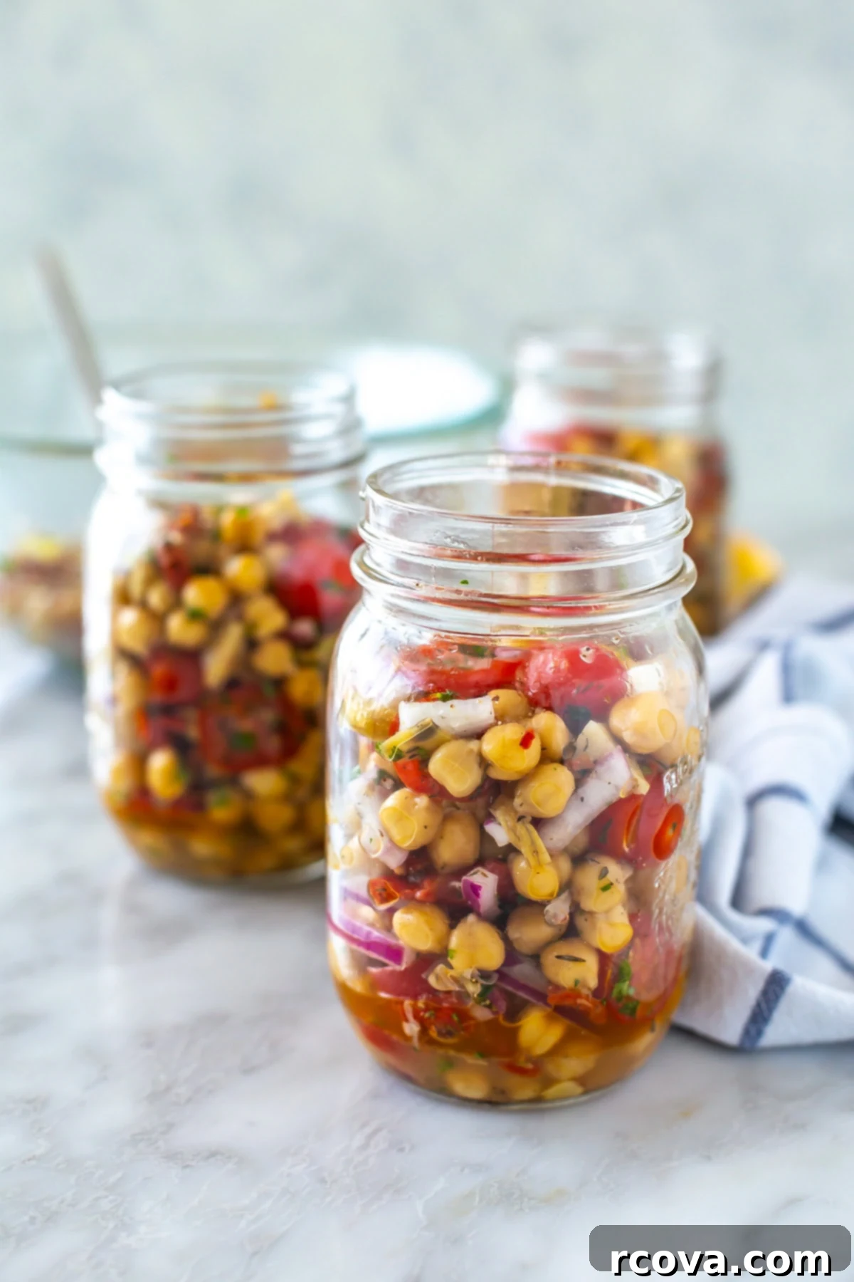 Effortless Mediterranean Chickpea Salad 9 Two neatly arranged mason jars filled with fresh Mediterranean chickpea salad, ready for healthy lunches on the go.