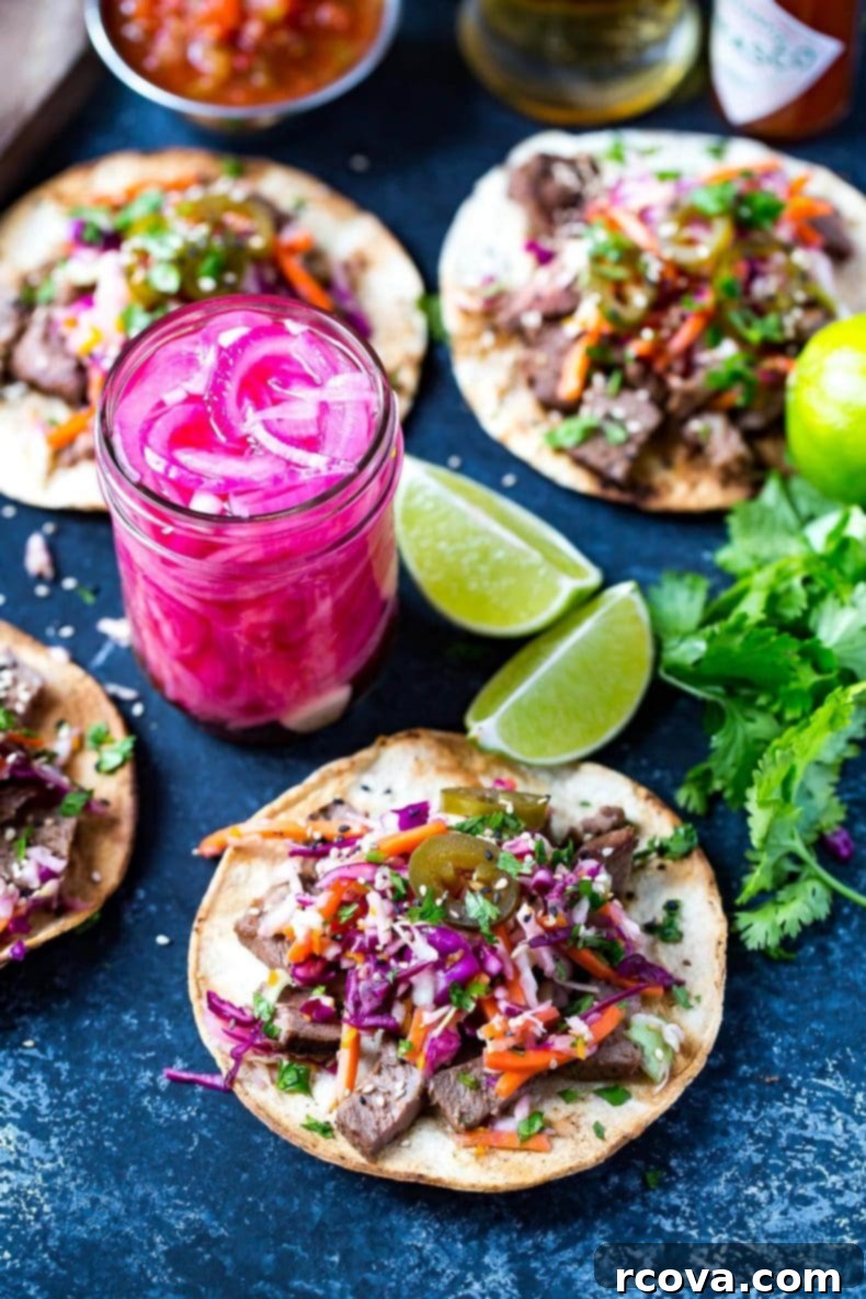 Korean BBQ Kalbi Tacos with Fresh Citrus Slaw 2 Tender, marinated Kalbi Beef Tacos topped with a vibrant citrus slaw, tangy pickled red onions, and fresh jalapenos, embodying a perfect fusion of Korean and Mexican flavors for an unforgettable meal.