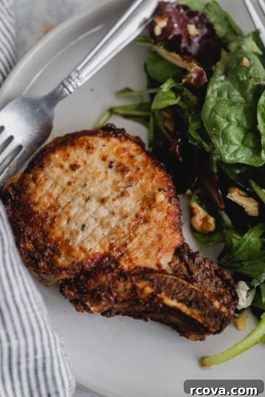 Crispy Air Fryer Dijon Pork Chops 4 A perfectly cooked Air Fryer Dijon Pork Chop, sliced to reveal its tender interior, served with fresh herbs.