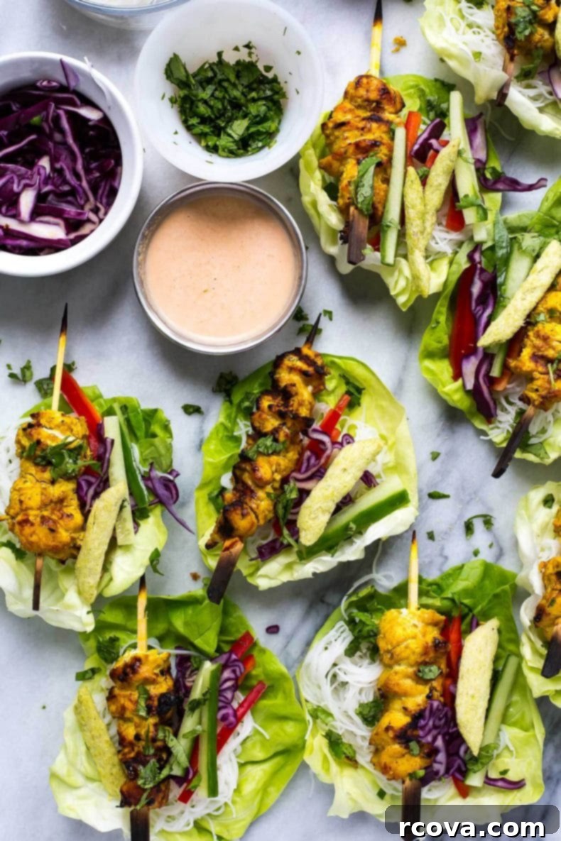 Crisp Chicken Satay Lettuce Wraps 2 Close-up of freshly assembled Chicken Satay Lettuce Wraps with creamy peanut sauce and fresh herbs, ready to be enjoyed.