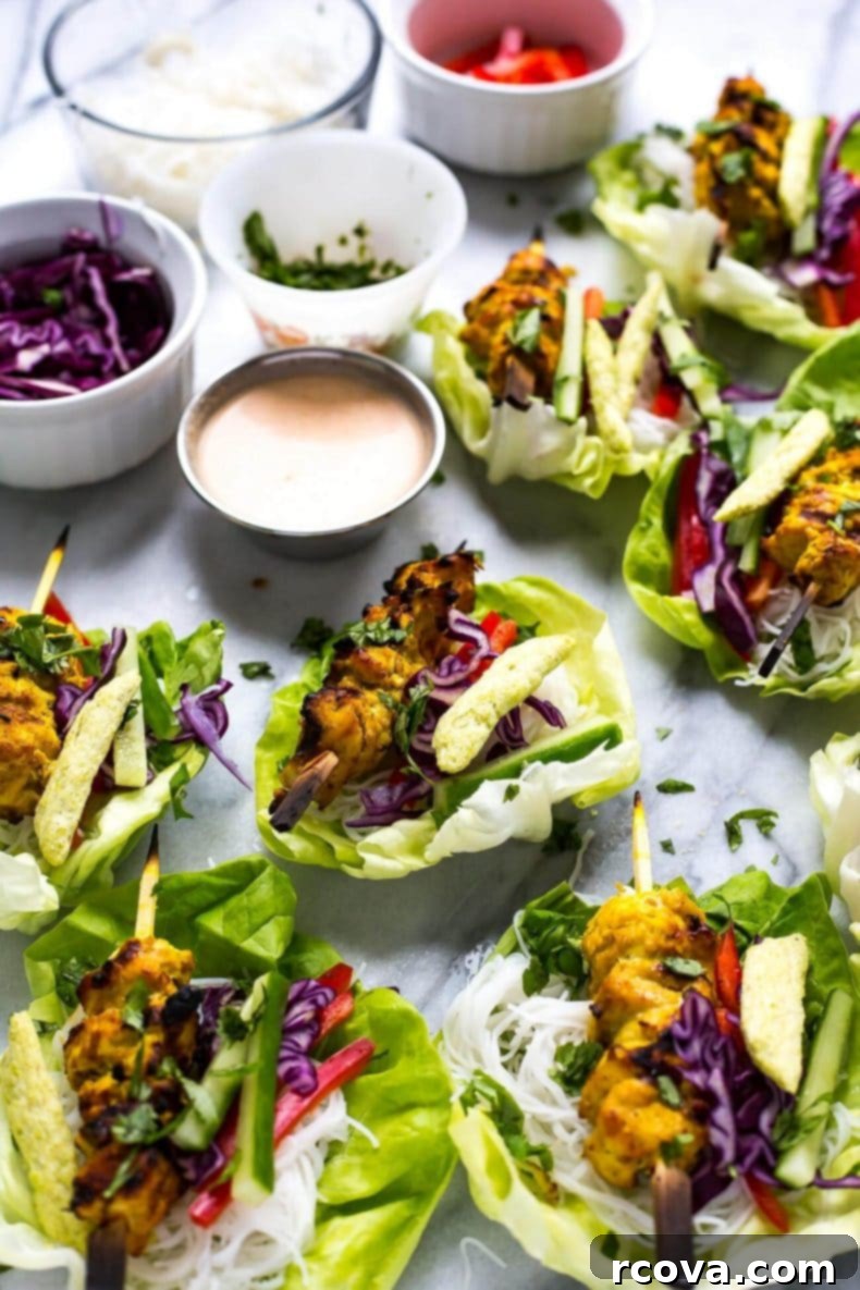 Crisp Chicken Satay Lettuce Wraps 6 Hand holding a perfectly wrapped Chicken Satay Lettuce Wrap, showcasing the fresh fillings and grilled chicken.