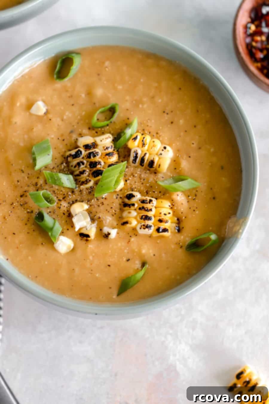 Speedy Smoky Chipotle Corn Cauliflower Chowder 2 Creamy Chipotle Corn and Cauliflower Chowder in a turquoise bowl garnished with charred corn kernels and fresh green onions